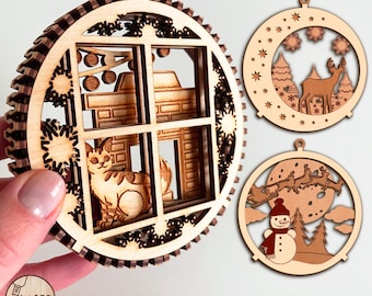 May include: Set of three laser-cut wooden ornaments. One features a cat in a window, another a deer in a snowy scene, and the third a snowman with Santa's sleigh. The ornaments are circular with intricate designs and a natural wood finish.