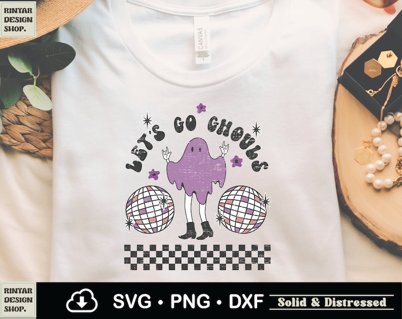 May include: A white t-shirt with a purple ghost wearing a black and white checkered pattern. The ghost is holding a disco ball and the text "Let's Go Ghouls" is written in a retro font.
