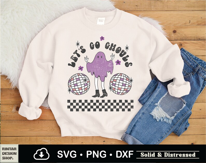 May include: A white sweatshirt with a distressed graphic design featuring a purple ghost with a disco ball and the text "Let's Go Ghouls".