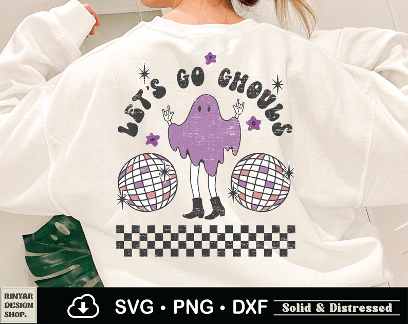 May include: White sweatshirt with a purple ghost wearing a disco ball and the text "Let's Go Ghouls" in a retro font. The ghost has a distressed look and is surrounded by stars and flowers.
