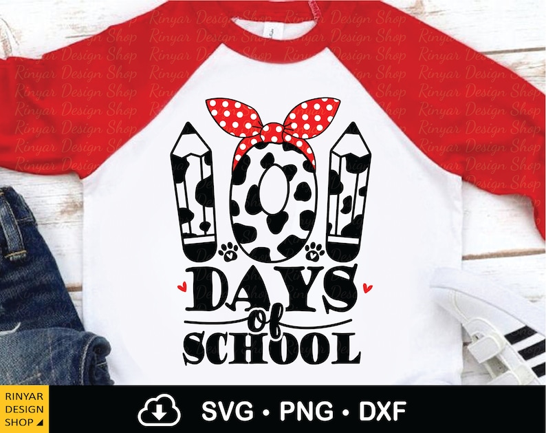 May include: A white and red raglan t-shirt with a black and white cow print design. The design includes two pencils and a bow with the text "100 Days of School".