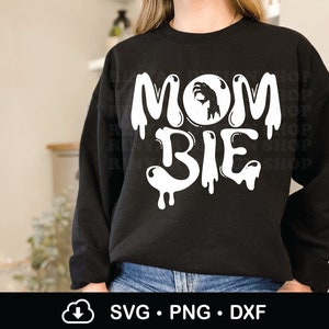 May include: Black sweatshirt with white dripping text that reads "MOM BIE" with a white hand inside a circle above the word "MOM".