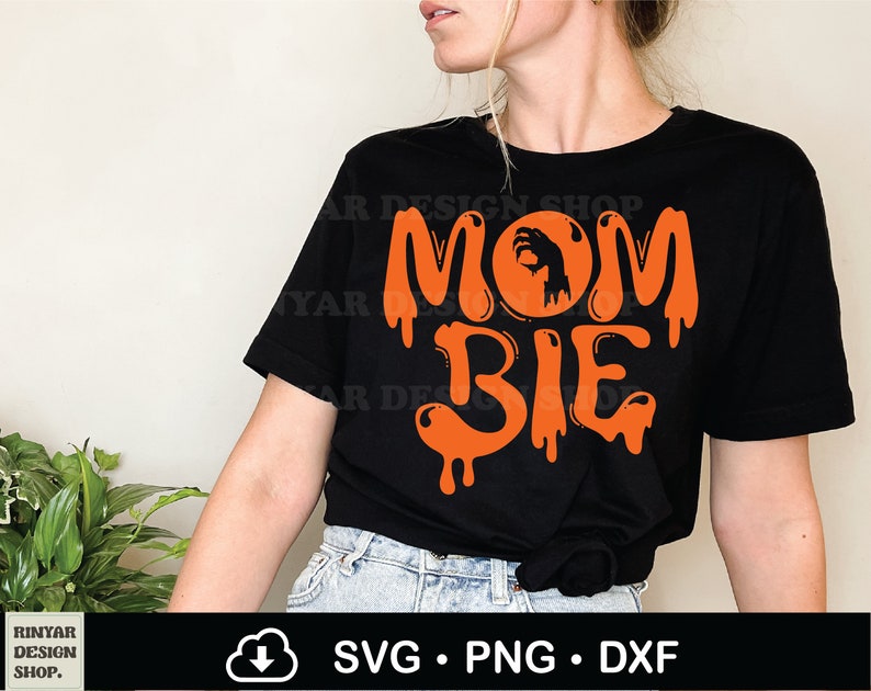 May include: Black t-shirt with orange text that reads "Mom Bie" with a zombie hand in a circle above the word "Mom".