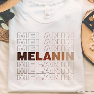 May include: White t-shirt with a brown and white graphic design that says "MELANIN" in a stacked, repeating pattern.