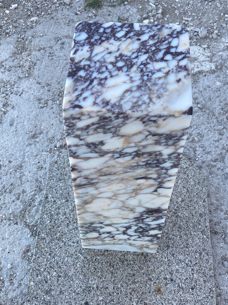 May include: A rectangular pedestal made of polished stone featuring a complex, swirling pattern of white, cream, and deep dark purple veins throughout its entire surface. The object has a smooth, reflective finish and a solid, block-like structure.