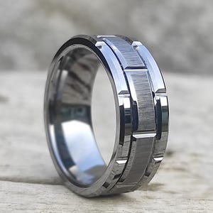May include: A silver tungsten carbide ring with a textured, grooved design.