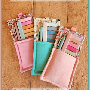 May include: Three fabric annotation bookmark holders in pink, teal, and pink with white polka dots. Each holder contains tabs, a pen, and a highlighter. The holders have floral patterned tops and are labeled "Annotation Bookmarks".