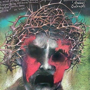 May include: A film poster for the movie "Na srebrnym globie" (On the Silver Globe). The poster features a stylised image of a man's face with a crown of thorns, painted in shades of red, black, and white. The title of the film is written in white lettering at the top of the poster.