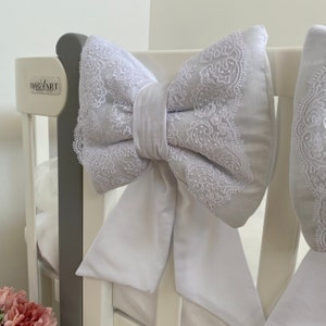Peut inclure: Bumper de lit bébé blanc avec un grand nœud blanc et une bordure en dentelle. Le pare-chocs est attaché au lit bébé avec des liens. Le pare-chocs de lit bébé est fait de tissu doux et est conçu pour protéger les bébés des bosses et des bleus.