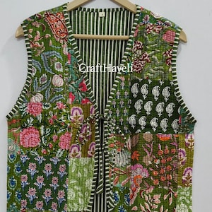 May include: A green quilted waistcoat with a floral patchwork design. The waistcoat has a V-neck and a tie closure at the front. The waistcoat is lined with a striped fabric.