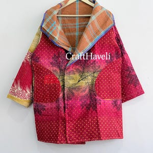 May include: A quilted jacket featuring a vibrant pink base with a dark leaf pattern and yellow dot accents. The interior lining displays a blue and orange plaid design. The garment includes two large front pockets and the text CraftHaveli.