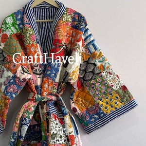 May include: A quilted robe featuring a patchwork design of various floral and botanical patterns in vibrant colors including red, blue, yellow, and green. The garment has wide sleeves, a tie waist, and a blue and white striped collar. Text reads CraftHaveli.