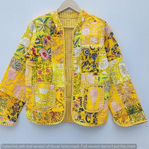 Pode incluir: Casaco amarelo de patchwork com padrões florais e geométricos. O casaco tem gola redonda, dois bolsos e é forrado com um tecido listrado. O texto "Craftl Haveli" é visível no casaco.