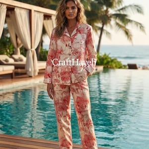 May include: A two-piece pajama set featuring a long-sleeved button-down shirt and matching trousers in a cream fabric with a red floral toile pattern. The shirt has a collar and a single chest pocket. The text CraftHaveli is visible in the center.