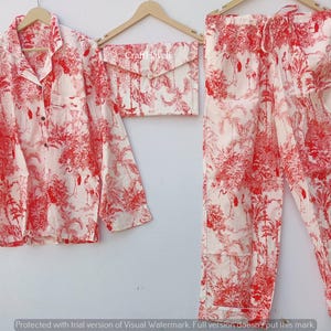 May include: A red and white pajama set with a floral print. The set includes a long-sleeved shirt with a button-up collar and matching pants.