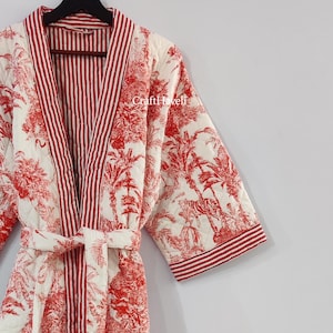 May include: A red and white quilted robe with a red and white striped trim. The robe has a floral and animal print with palm trees and tigers. The robe has a tie belt and is made of cotton.