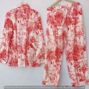 May include: A red and white pajama set with a floral print featuring birds. The set includes a long-sleeved shirt and pants.