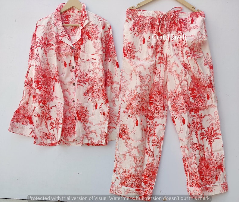 May include: Red and white pyjama set featuring a crane and palm tree print. The set includes a long-sleeved shirt and matching trousers.