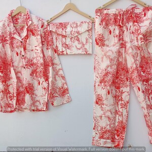 May include: A red and white pajama set with a floral print. The set includes a long-sleeved shirt with a button-up collar and matching pants.