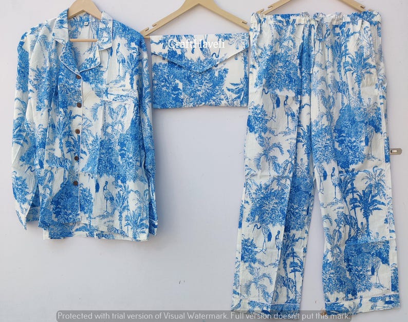 May include: A white pajama set with a blue and white floral print. The set includes a long-sleeved shirt with a collar and a pair of pants.