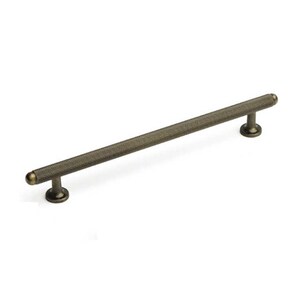 May include: A long, antique brass cabinet pull with a textured, diamond-shaped pattern. The pull has rounded ends.