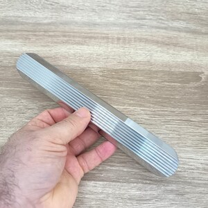 May include: A silver metal handle with a ridged surface. The handle is about 12 inches long.