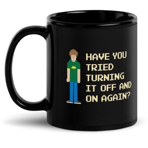 Puede incluir: Taza de café negra con una imagen pixelada de una persona y el texto "¿Has probado a apagarlo y encenderlo de nuevo?"