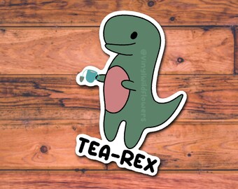 May include: A sticker featuring a cartoon dinosaur holding a teacup. The dinosaur is green with a pink belly and a smiling face. The text "TEA-REX" is below the dinosaur in a bold, black font.
