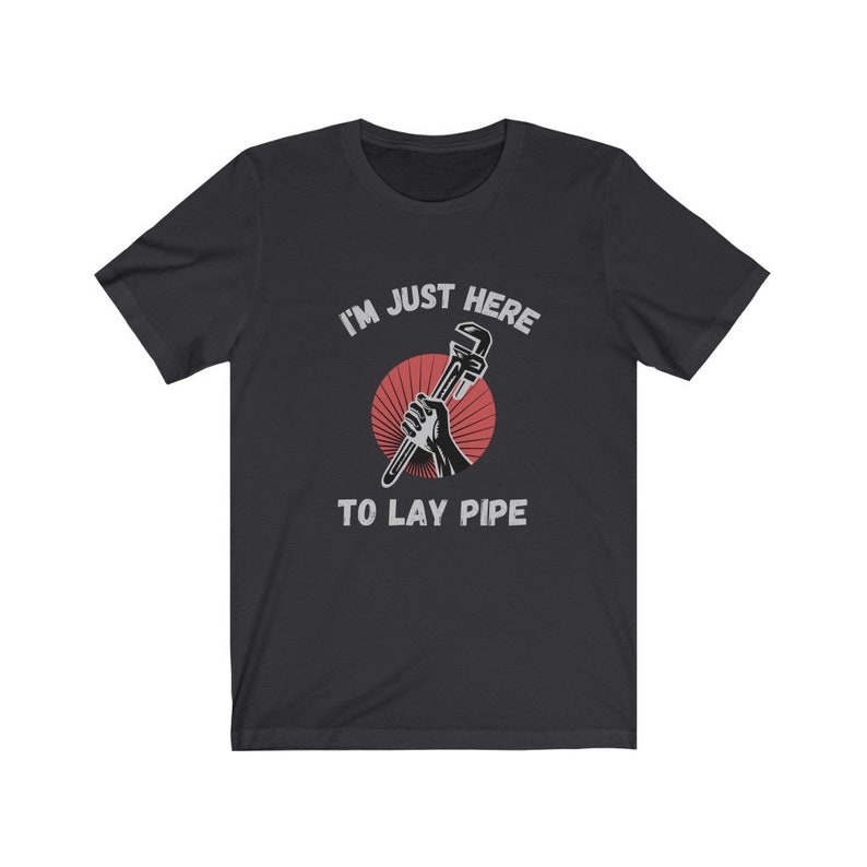 May include: A black t-shirt with a white graphic of a hand holding a wrench with the text "I'm just here to lay pipe".