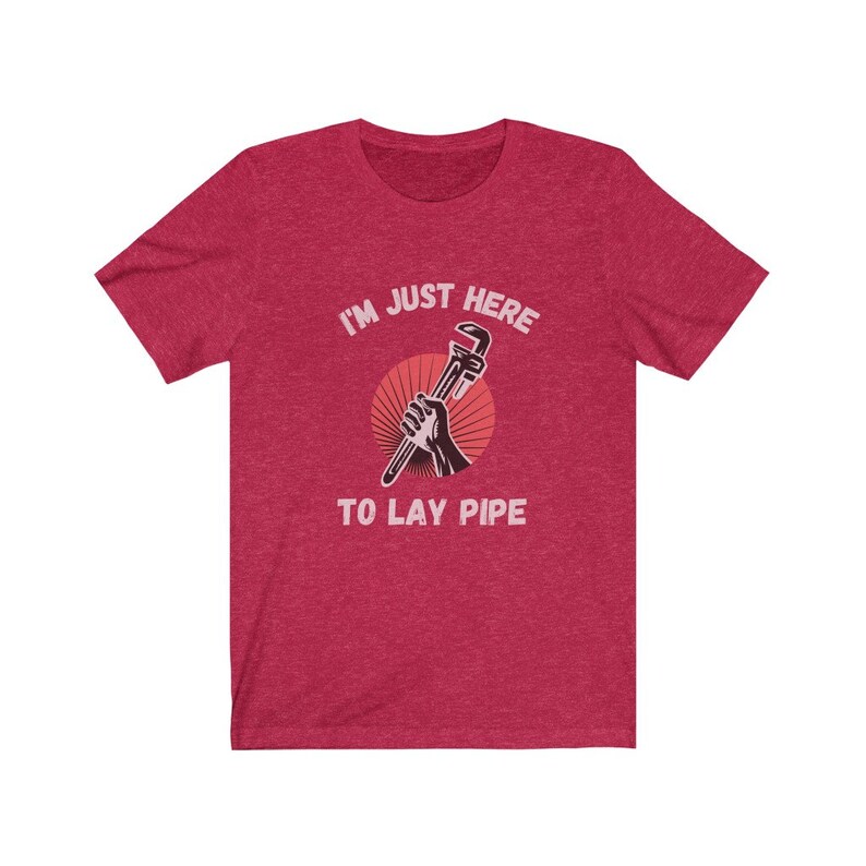 May include: Red heather t-shirt with a graphic of a hand holding a wrench with the text "I'm just here to lay pipe".