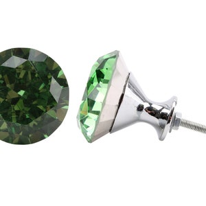 May include: Green crystal cabinet knob with a silver base and screw. The crystal is faceted and has a diamond shape.