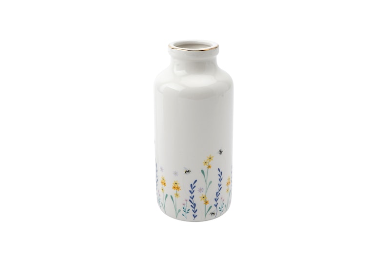 May include: White ceramic vase with a gold rim and a floral design featuring yellow, blue, and green flowers and bees.