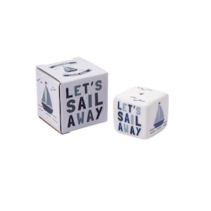May include: White ceramic salt and pepper shaker set with a blue sailboat design. The shakers have the text "Let's Sail Away" on them.