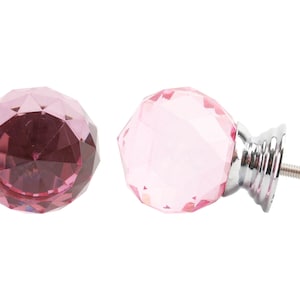 以下が含まれることがあります： ピンクのクリスタル製のキャビネットノブ2個。1つはシルバーのベースとネジ付き。ノブはファセットカットされており、ダイヤモンドのような形をしています。