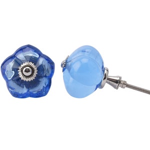 May include: Two blue glass cabinet knobs, one with a flower shape and the other round, with a silver metal screw.