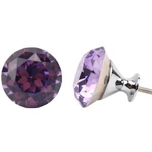 May include: A purple crystal cabinet knob with a silver base and screw. The crystal is faceted and has a diamond shape.