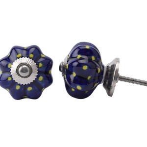 May include: Two blue ceramic cabinet knobs with yellow polka dots. One knob is shown from the side with a silver screw, the other is shown from the top.
