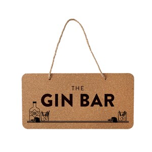 Puede incluir: Un letrero de corcho con un asa de cuerda que dice "The Gin Bar". El letrero tiene una ilustración en blanco y negro de una botella de ginebra, un vaso de ginebra y una rodaja de limón.