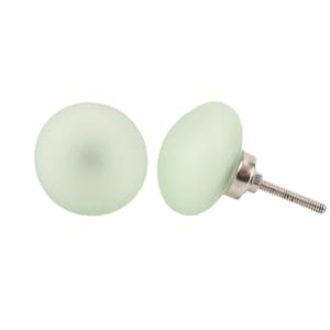 May include: Two frosted glass cabinet knobs in a light green colour. One knob has a silver screw attached.