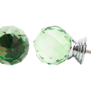 May include: Two green crystal cabinet knobs with a silver base and screw. One knob is shown from the side, the other is shown from the front.