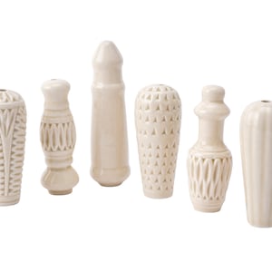May include: Six white ceramic drawer pulls with different embossed designs. The pulls are all different shapes and sizes.