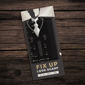 Puede incluir: Una tarjeta multiherramienta negra 18 en 1 con peine, regla y cortador de alambre. La tarjeta está diseñada para parecer un traje y corbata, con el texto "FIX UP LOOK SHARP". Medidas en cm.