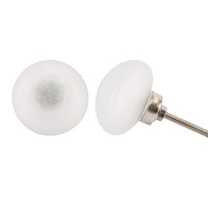 May include: Two white frosted glass cabinet knobs with a silver screw. One knob is shown with the screw attached.