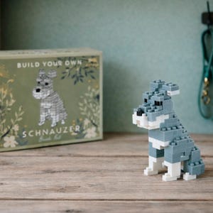 May include: A set of three ceramic mugs with a speckled, matte finish in cream, light grey, and dark grey. Each mug has a simple, minimalist design, ideal for tea or coffee.