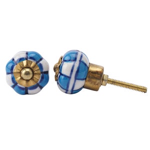 Könnte beinhalten: Zwei blaue und weiße Keramik-Schrankknöpfe mit einer goldenen Schraube. Die Knöpfe haben ein geometrisches Muster.