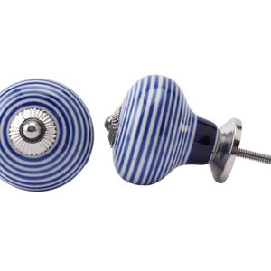 May include: Two ceramic cabinet knobs with a blue and white striped pattern. The knobs have a round shape with a silver-coloured metal base and screw. One knob is viewed from the front, the other from the side.