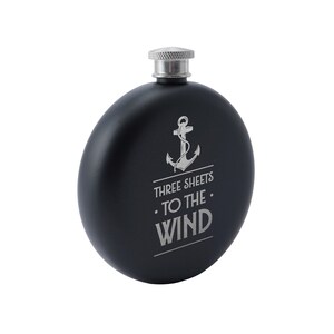May include: Black metal flask with a silver anchor and the text "Three Sheets To The Wind".