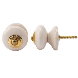May include: White ceramic cabinet knob with a gold accent. The knob has a screw for installation.