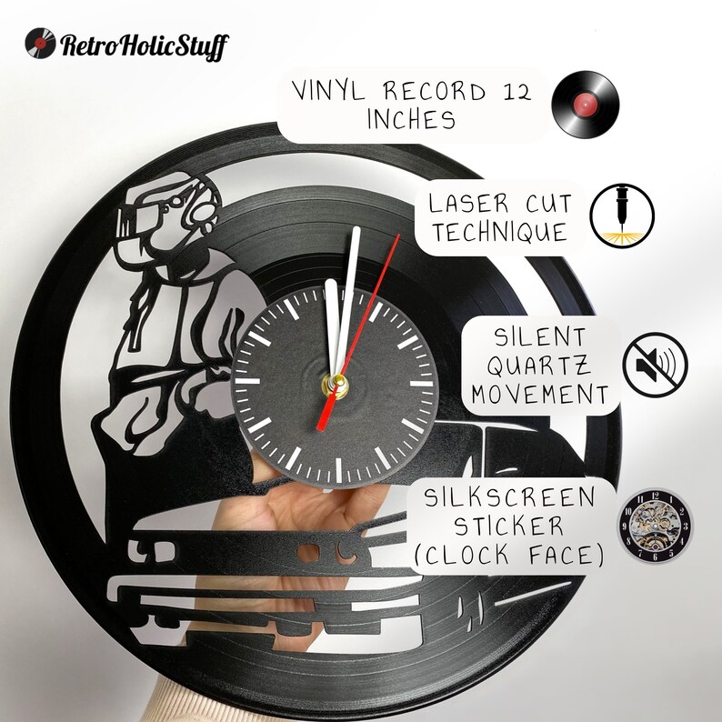 May include: A black vinyl record clock featuring a silhouette of a person driving a car. The clock is 12 inches in diameter and has a laser cut design. The clock face is a silkscreen sticker. The clock has a silent quartz movement.