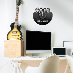 Böhse Onkelz vinyl wall clock hanging in a creative workspace with guitar and computer, ideal for a music-themed interior.
